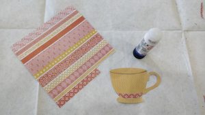 a cutout paper teacup, a glue stick, a square of decorative paper