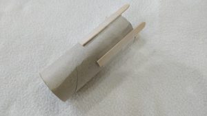 Popsicle sticks glued to the outside of a toilet paper tube