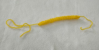 A small tube of yellow french knitted yarn.