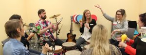 A group of people sitting in a circle with drums and hand instruments.